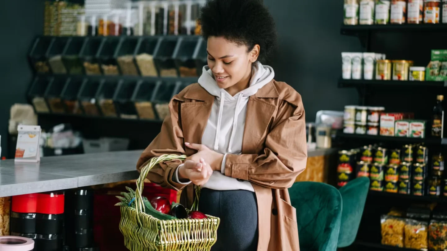 Pregnant woman shops for fresh vegetables at an organic grocery store.