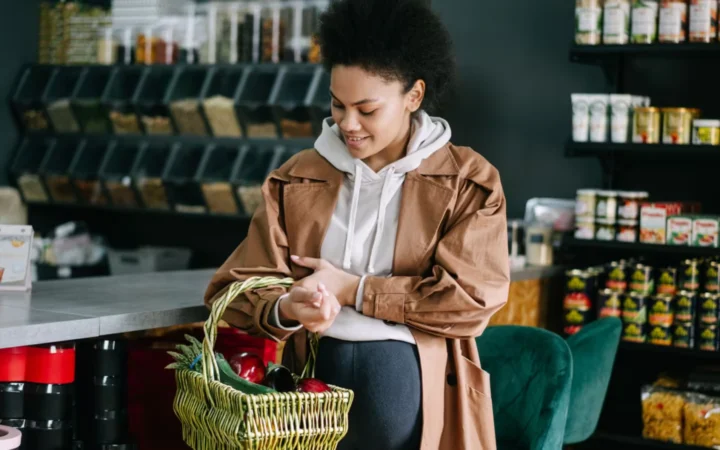 A pregnant woman shops for fresh vegetables at an organic grocery store.