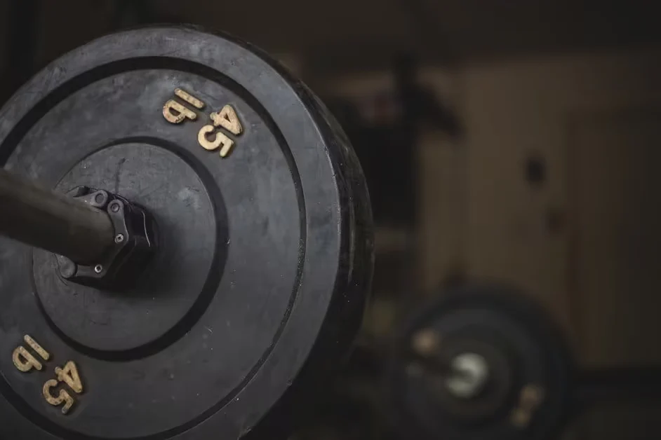 A loaded 45 pound barbell plate in a dim gym