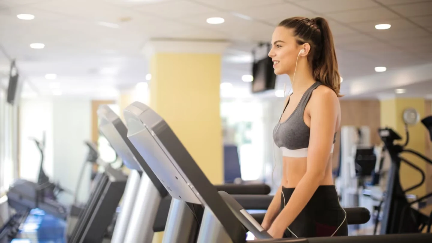Woman enjoying a workout on a treadmill indoors, promoting fitness and health.