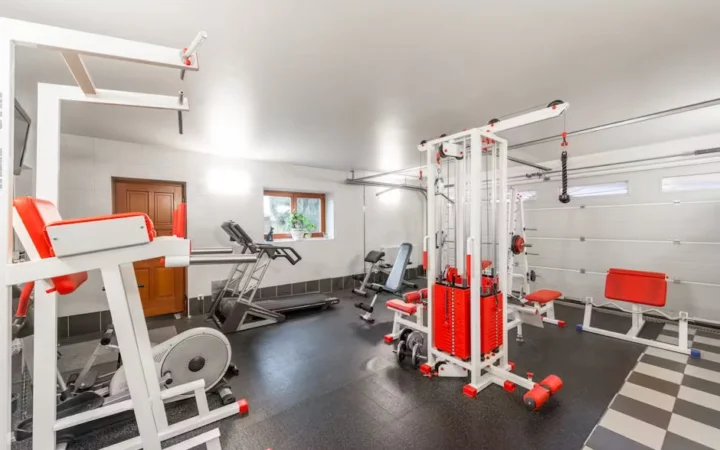A home gym with a cable machine, bench and free weights