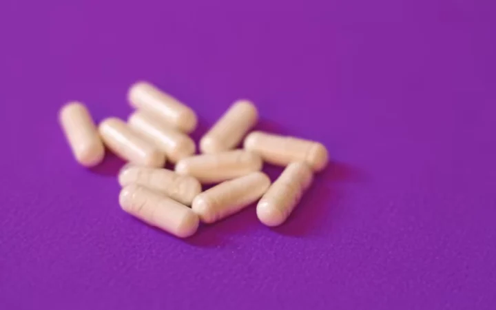 Pale capsules scattered on a purple background