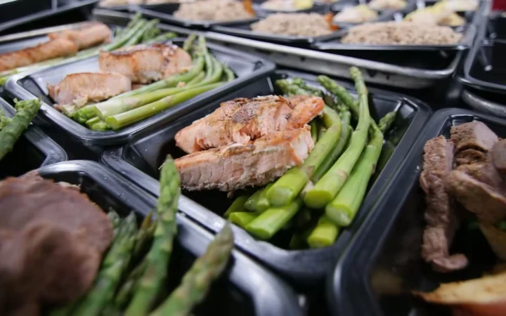 Meal trays of baked salmon with asparagus and rice