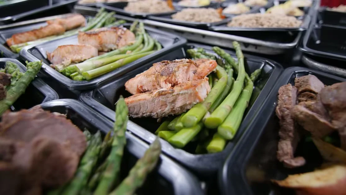 Meal trays of baked salmon with asparagus and rice