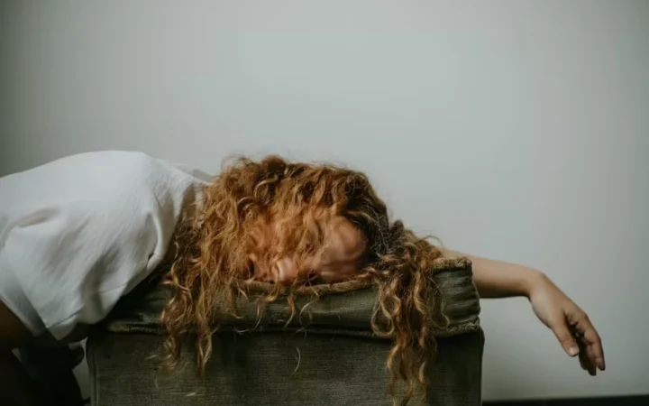 A woman collapsed face-down over the arm of a chair