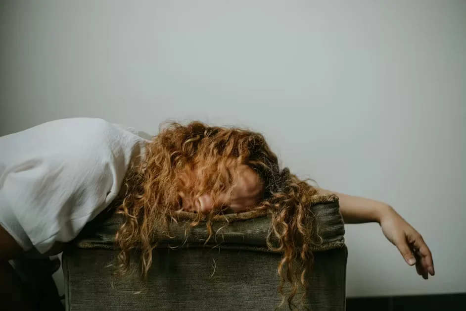A woman collapsed face-down over the arm of a chair