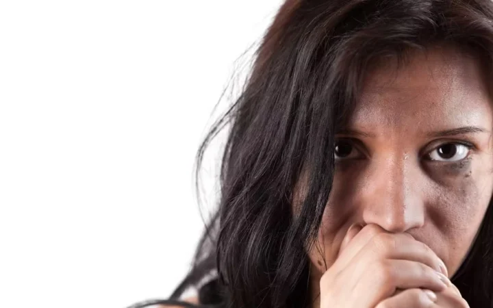A woman holding one hand over her mouth