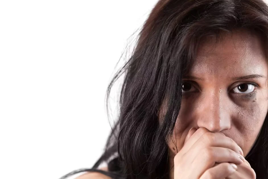 A woman holding one hand over her mouth