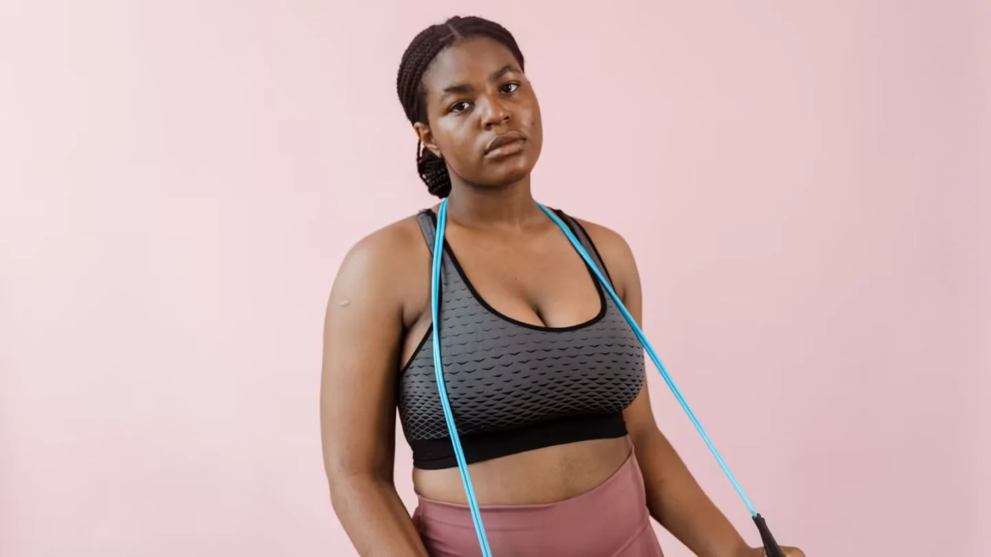 Young woman in stylish activewear using a resistance band during a workout session.