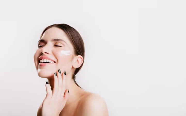 A woman smiling with moisturiser patches on her cheeks