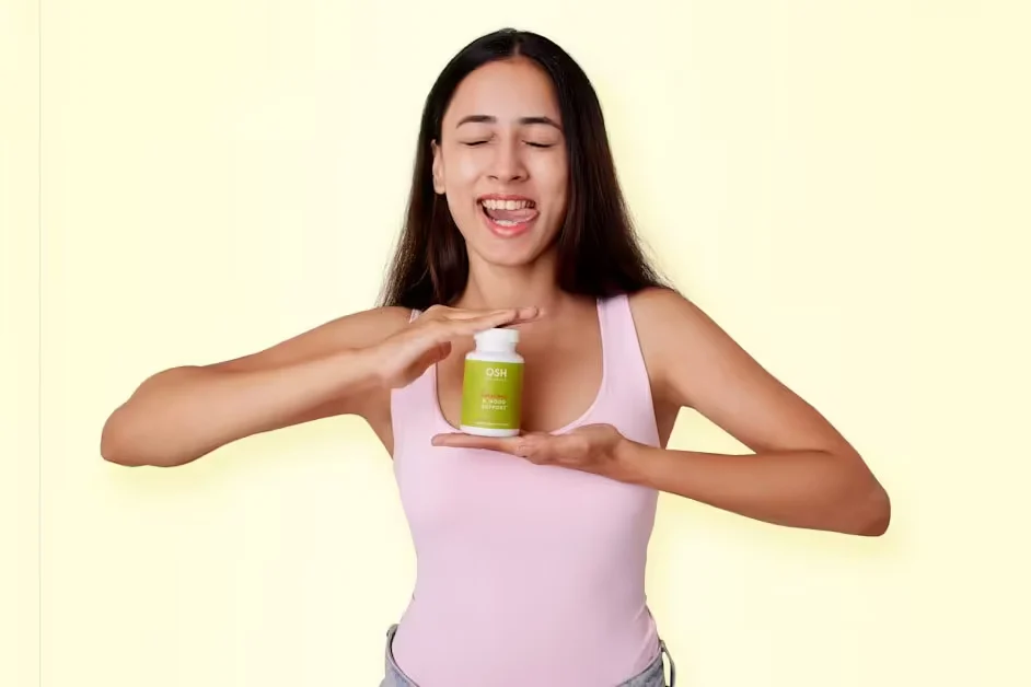 A woman holding up a bottle of supplements