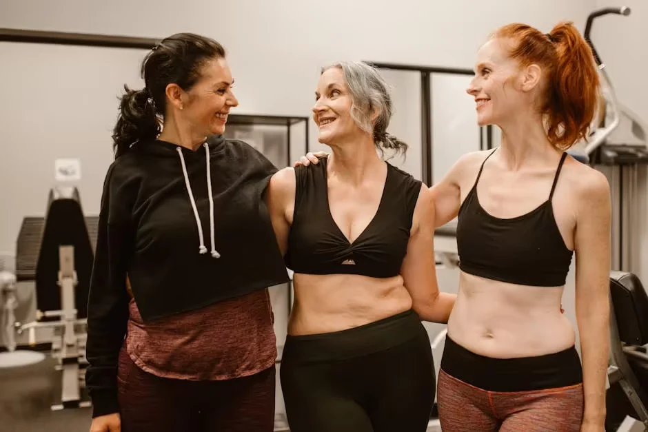 Three women of different ages together in a gym, one grey-haired