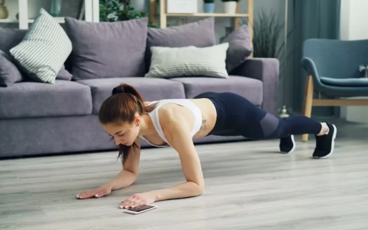 A woman holding a plank position in a living room