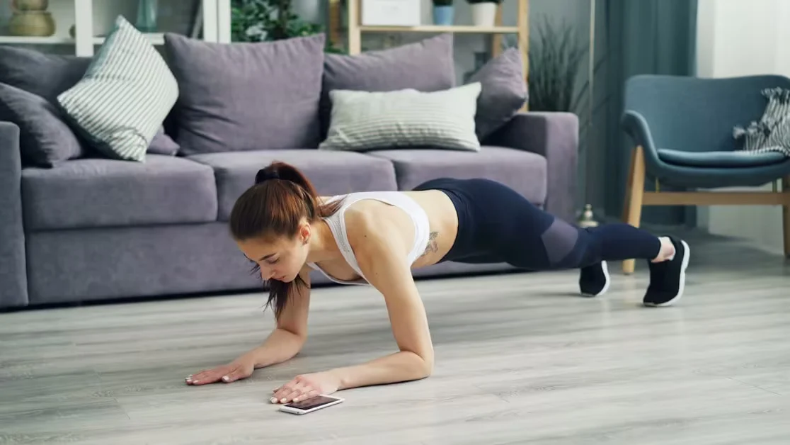 A woman holding a plank position in a living room