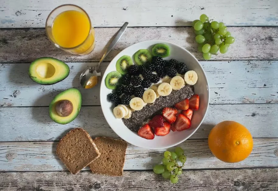A breakfast spread of fruit, avocado, rye bread and juice