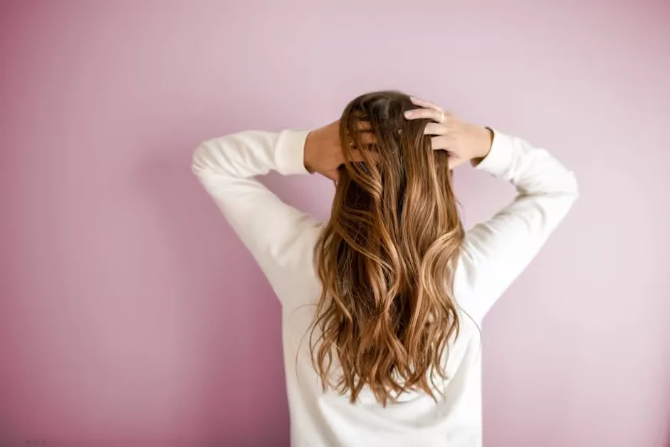 A woman running both hands through long hair