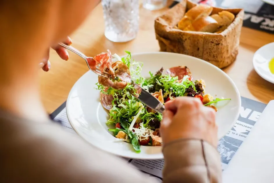 A woman eating a salad at a cafe table