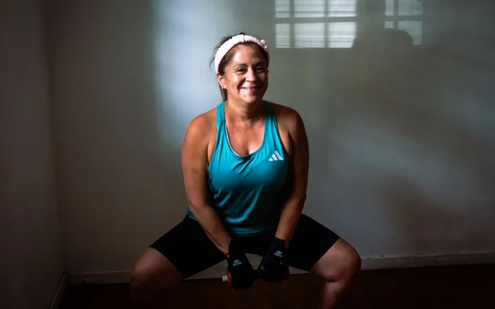 Healthy woman working out indoors with dumbbells, promoting fitness and strength.
